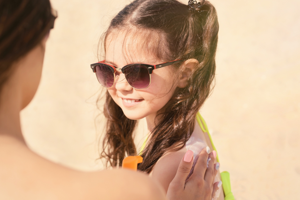 Woman putting sunscreen on child