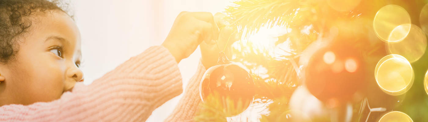 young girl decorating Christmas tree