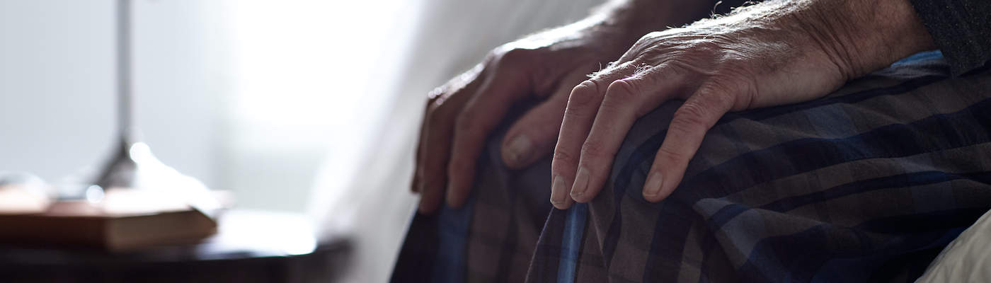 Man Sitting on Edge of Bed