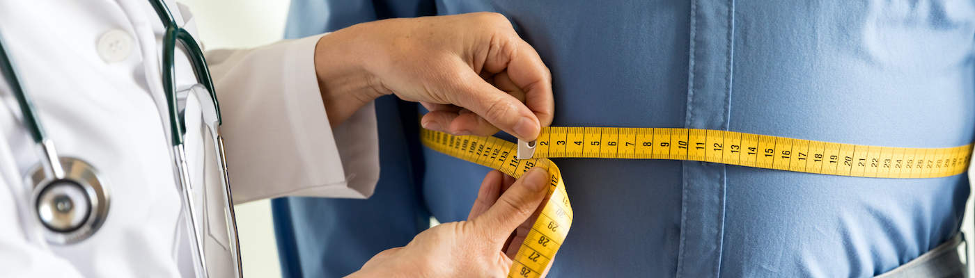 Doctor measuring patient waistline