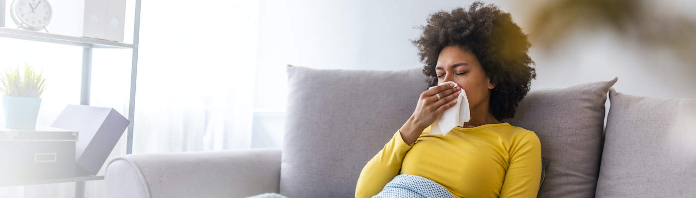 Woman Sneezing Into Tissue