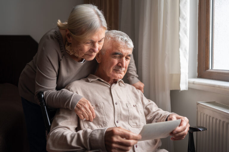 Senior Couple Looking At An Old Photo At Home
